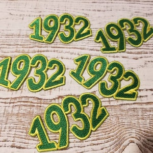 Könnte beinhalten: Sechs grüne und gelbe gestickte Aufnäher mit dem Jahr 1932.