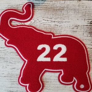Op de afbeelding: Rode vilt olifant applique met witte omtrek en het nummer 22 in wit vilt.
