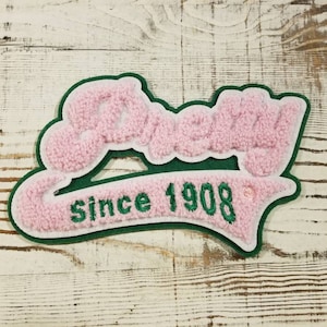 May include: Pink and green felt patch with the word "Since 1908" in green embroidery.
