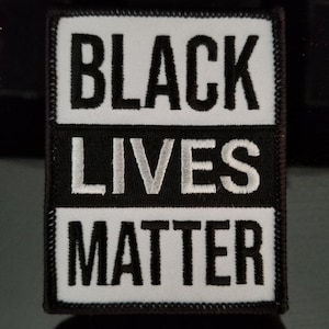 May include: Black and white embroidered patch with the text "Black Lives Matter".