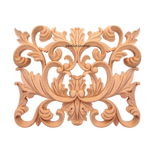 May include: A detailed wooden carving with a symmetrical design featuring intricate swirls and leaves. The carving is made of light brown wood and has a smooth finish.