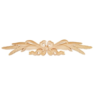 May include: A wooden decorative trim with a carved design of a bow and wheat stalks. The trim is light brown in color and has a smooth finish.