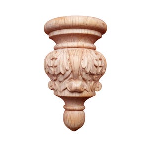 May include: A carved wooden furniture leg with a detailed floral design. The leg features a rounded top, a central section with carved leaves, and a bulbous base. The wood has a natural, light brown color.