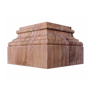 Puede incluir: Base arquitectónica de madera de forma cuadrada. Presenta un diseño en capas con elementos curvos y rectangulares. La madera muestra una veta natural y un color marrón cálido. Probablemente para una columna o elemento decorativo.