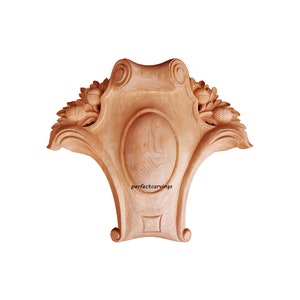 May include: A wooden carved ornament with a central oval shape and intricate leaf and acorn details. The ornament is unfinished and ready to be painted or stained. The text "perfectcarvings" is visible on the ornament.