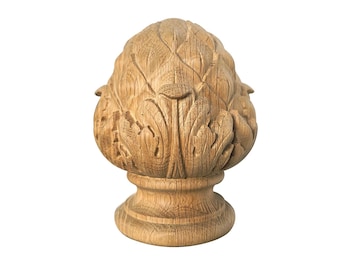 May include: A carved wooden finial in the shape of a pine cone. The finial is light brown with detailed leaf carvings and a round base. The wood grain is visible throughout the piece, adding texture and depth to the design.