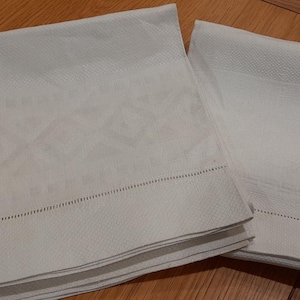 Könnte beinhalten: Set aus drei Keramikbechern mit gesprenkelter, matter Oberfläche. Die Becher sind in Creme-, Hellgrau- und Dunkelgrautönen gehalten. Jede Tasse hat ein schlichtes, minimalistisches Design, ideal für Kaffee oder Tee.