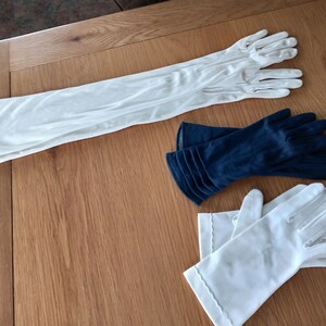 Peut inclure: Trois paires de gants, une paire est longue et blanche, une paire est courte et blanche, et une paire est courte et bleu marine.