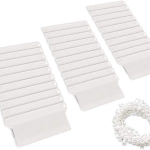 May include: Several white vertical blind slats and a looped chain are shown against a white backdrop. The slats are rectangular with a folded bottom edge. The chain is coiled and appears to be made of small, white beads. The image is well-lit.