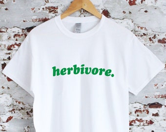 May include: White t-shirt with a green graphic that says "herbivore."