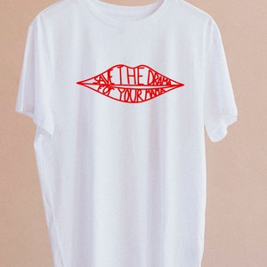 May include: White t-shirt with a red outline of lips that says "Save the drama for your mama".