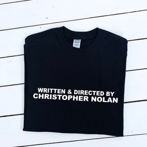 Written and Directed by Christopher Nolan T-shirt, multiple colour tees, mens and womens sizes, movie clothing, movie gift idea