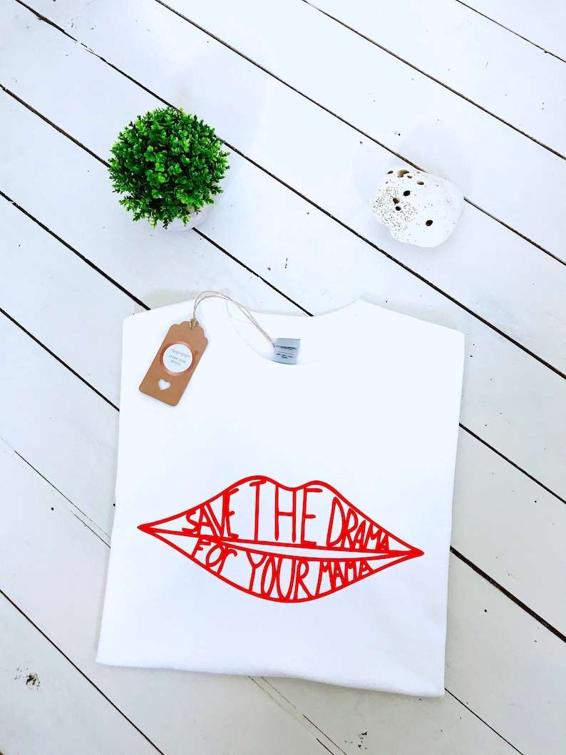 May include: White t-shirt with a red lip design that says "Save the drama for your mama".