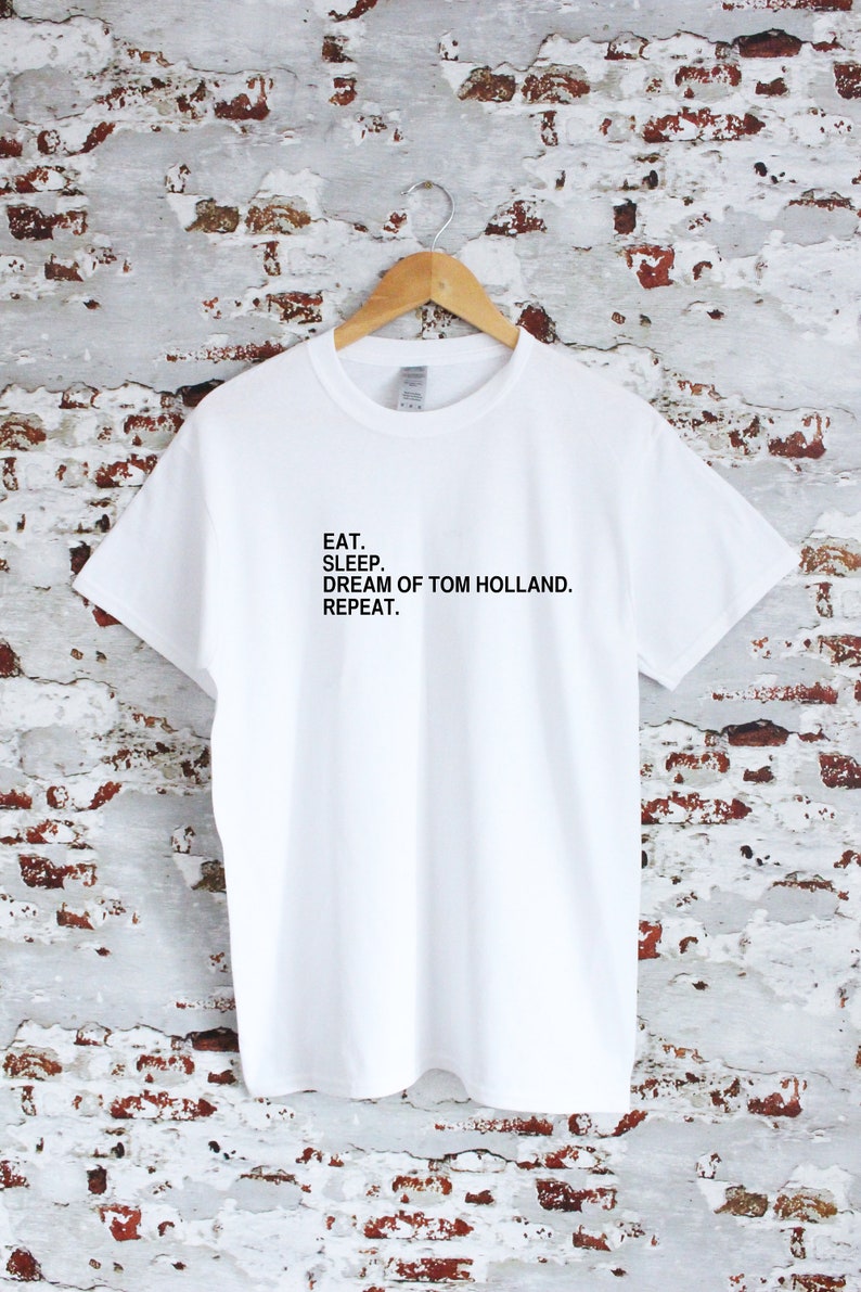 May include: White t-shirt with black text that reads "Eat. Sleep. Dream of Tom Holland. Repeat."
