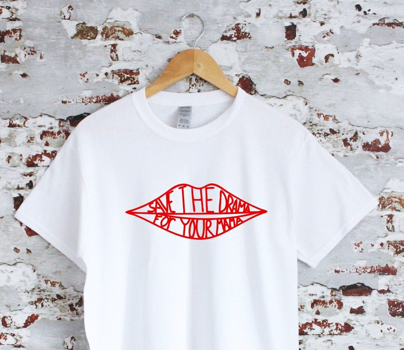 May include: White t-shirt with a red graphic of a pair of lips with the text "Save the drama for your mama" inside.