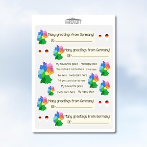 May include: A white postcard with the text "Many greetings from Germany!" and "DE-" repeated multiple times. The postcard features colorful map outlines of Germany and the text "My favourite place My happy place".