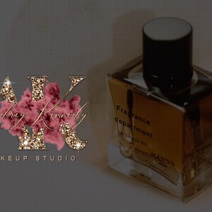 May include: Gold glitter letters "AK" with the text "Audrey Kennedy Makeup Studio" below. A clear glass bottle with a black cap and the text "Fragrance department Aromatic oil MANGO" on the label.