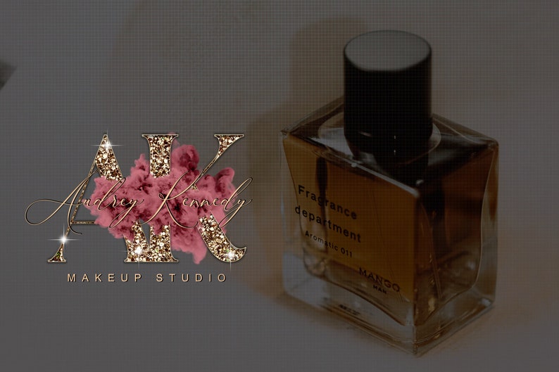 May include: Gold glitter letters "AK" with the text "Audrey Kennedy Makeup Studio" below. A clear glass bottle with a black cap and the text "Fragrance department Aromatic oil MANGO" on the label.
