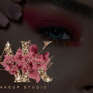 May include: Gold glitter letters "AK" with a pink watercolor design behind them. The letters are surrounded by sparkling lights. The text "Audrey Kennedy Makeup Studio" is below the letters.