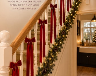 May include: Deep red velvet bows tied to white staircase spindles, accompanied by a green garland with pinecones and warm white lights. Text reads: HANDMADE STAIRCASE BOWS, MADE FROM LUXURY VELVET, READY TO TIE ONTO YOUR STAIRCASE SPINDLES.
