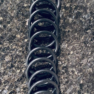 May include: A stack of ten black rubber O-rings.