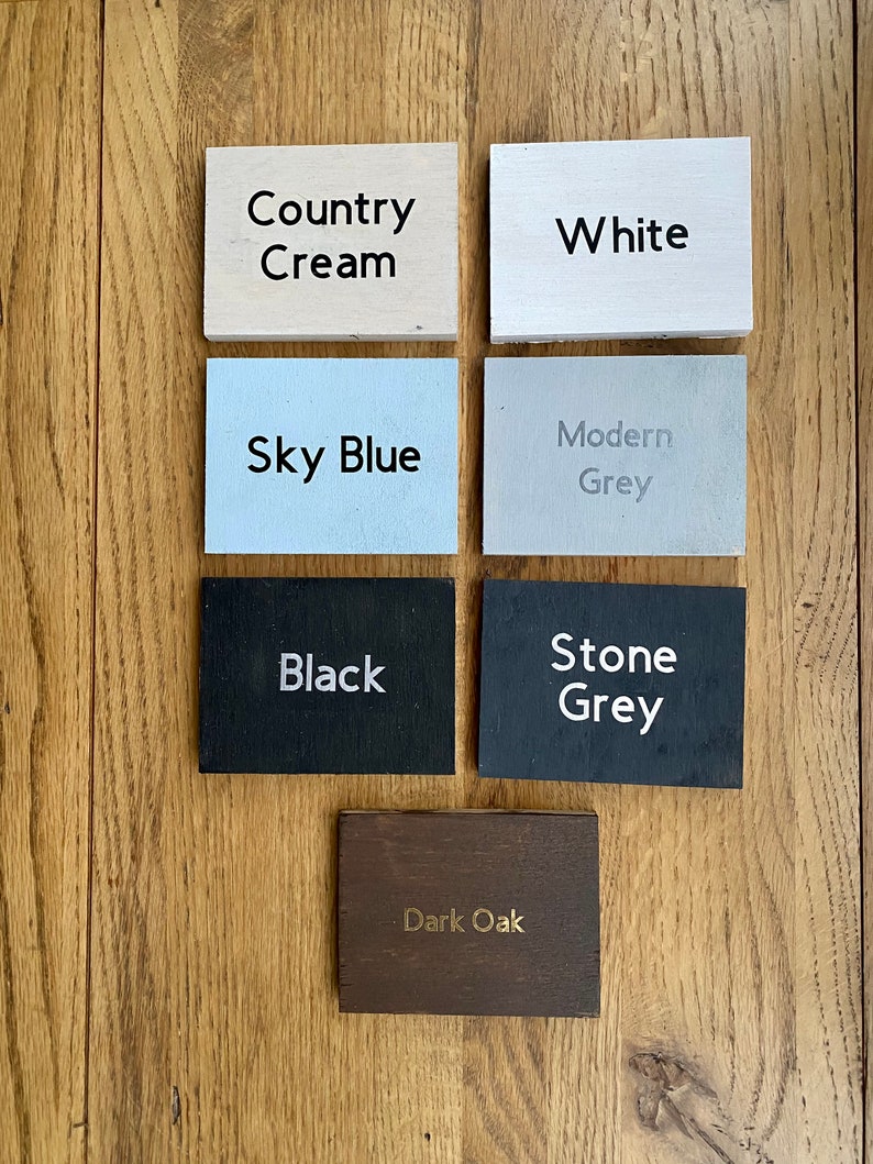 May include: Six wooden samples of different colors and finishes. The colors are Country Cream, White, Sky Blue, Modern Grey, Black, and Stone Grey. The last sample is Dark Oak.