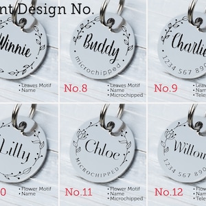 May include: A collection of six silver pet ID tags with various names and designs. Each tag is round, featuring a name in elegant script surrounded by a floral or leaf motif. Some tags include a phone number or the word "microchipped".