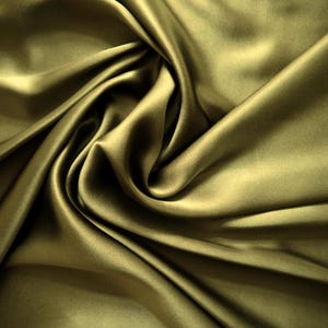 May include: Close-up of olive green satin fabric with soft folds and highlights. The fabric has a smooth, luxurious texture and a subtle sheen. The folds create shadows and depth, enhancing the fabric's visual appeal. Ideal for apparel, home decor, and craft projects.