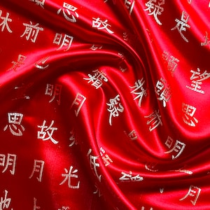 K&ouml;nnte beinhalten: Ein leuchtend roter Satin-Stoff mit einem Wirbelmuster. Der Stoff ist mit goldenen chinesischen Schriftzeichen verziert. Der Satin hat einen gl&auml;nzenden Glanz, und die Falten erzeugen Schatten, die dem Design Tiefe verleihen.