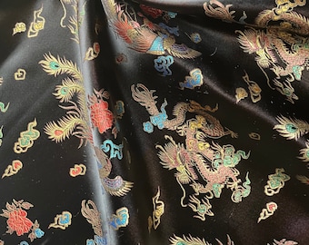 Könnte beinhalten: Schwarzer Satin-Stoff mit einem aufwendigen Muster aus farbenfrohen Drachen, Phönixen und Wolkenmotiven. Das Design beinhaltet Rot-, Gold-, Blau- und Grüntöne und schafft einen reichen und detaillierten Stoff.