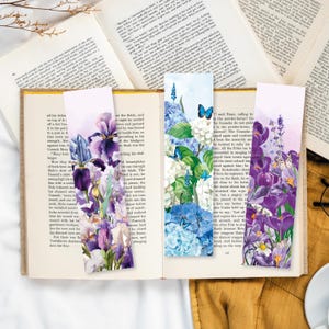 Könnte beinhalten: Drei Blumen-Lesezeichen-Designs mit violetten Iris, blauen Hortensien und violetten Krokus mit Schmetterlingen. Die Lesezeichen sind auf weißem Hintergrund gedruckt.