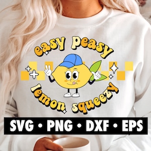 May include: A white sweatshirt featuring a yellow lemon character design. The lemon is wearing a blue hat and holding a peace sign. The text surrounding the lemon reads "easy peasy lemon squeezy".