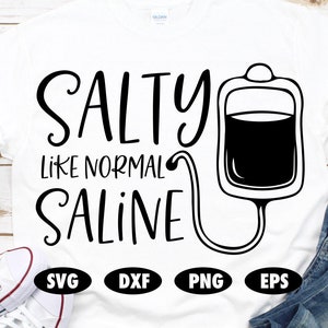 May include: White t-shirt with black text that reads "Salty like normal saline" and a black silhouette of an IV bag and tubing. The shirt also has black text that reads "SVG, DXF, PNG, EPS".