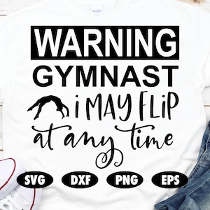 Puede incluir: Camiseta blanca con texto negro que dice "WARNING GYMNAST i MAY FLIP at any time". Una silueta de una gimnasta haciendo un salto mortal hacia atrás está por encima del texto. Las palabras "SVG", "DXF", "PNG", y "EPS" están en círculos negros debajo del texto.