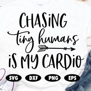Può includere: Maglietta bianca con testo nero che recita "Chasing tiny humans is my cardio" con una freccia che punta a destra. Il testo è in un font di scrittura a mano. Sotto il testo ci sono quattro cerchi neri con le parole "SVG", "DXF", "PNG" e "EPS" in bianco.