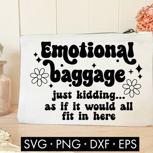 May include: White canvas makeup bag with black text that reads "Emotional baggage just kidding... as if it would all fit in here". The text is in a retro font style. There are two black and white flower illustrations on the bag.
