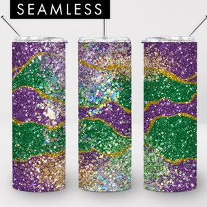 May include: Three stainless steel tumblers with lids and straws. The tumblers are decorated with a green, purple and gold glitter pattern. The pattern is a swirl of colours with gold accents.