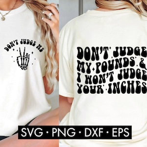 Puede incluir: Camiseta blanca con texto negro que dice "Don't Judge Me" con un signo de paz y un gráfico de mano de esqueleto en la parte delantera. La parte posterior de la camiseta tiene texto negro que dice "Don't Judge My Pounds & I Won't Judge Your Inches" en una fuente retro.