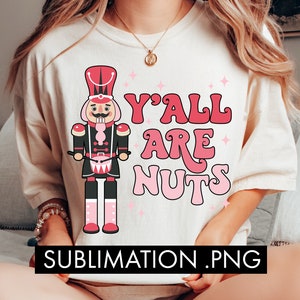 May include: A white t-shirt with a pink and black nutcracker illustration and the text "Y'all are nuts" in pink letters.
