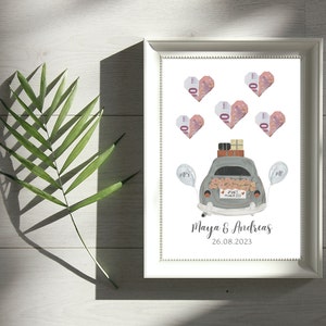 May include: A white picture frame with a white background. The frame contains a drawing of a gray car with a "Just Married" sign on the back. The car is decorated with flowers and has luggage on the roof. There are pink hearts with the number 10 on them around the car. The text "Maya & Andreas 26.08.2023" is at the bottom of the frame.