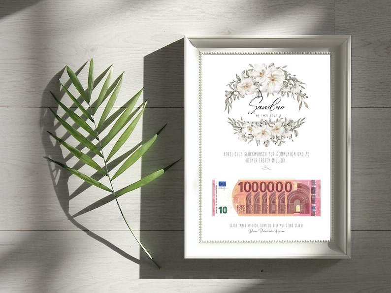 May include: A white framed print with a floral design and the name "Sandro" in cursive. The print also includes a 10 Euro bill with the text "1000000" printed on it. The text "Herzlichen Gl&uuml;ckwunsch zur Kommunion und zu deiner ersten Million" is also included on the print.