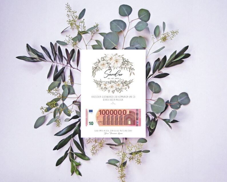May include: A white card with a floral design and the name "Sandro" written in black script. The card has a 10 Euro bill with the text "1000000" printed on it. The card is surrounded by green leaves.