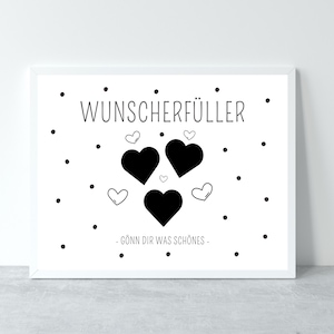 May include: A white framed print with black text that reads "Wunsch erf&uuml;ller" and a graphic of three black hearts with smaller white hearts inside. The text below the hearts reads "G&ouml;nn dir was sch&ouml;nes."