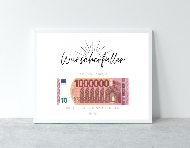 May include: A white framed print with a black and white illustration of a starburst. The text "Wunscherfuller" is written in black cursive script. Below the illustration is the text "DINE ERSTE MILLION!" in black text. A pink and green 10 euro bill is shown with the number "1000000" printed on it. The text "ALLES LIEBE UND GUTE ZUM GEBURTSTAG" is written in black text below the bill.