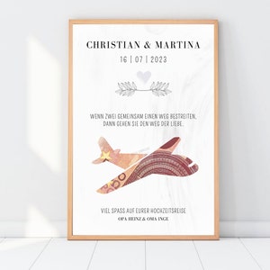 K&ouml;nnte beinhalten: Ein gerahmter Druck mit wei&szlig;em Hintergrund und einem stilisierten Flugzeug aus Geld. Der Text lautet "Christian & Martina 16|07|2023" und "Wenn zwei Menschen gemeinsam einen Weg bestreiten, gehen sie den Weg der Liebe." Der Druck enth&auml;lt auch den Text "Viel Spass auf eurer Hochzeitsreise Opa Heinz & Oma Inge".