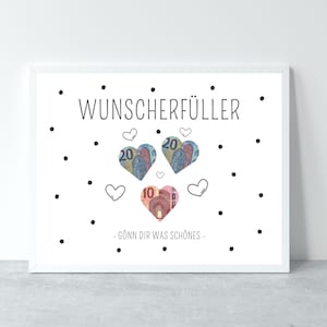 May include: A white framed print with the text "Wunsch erf&uuml;ller" in black. The print features a design of hearts made of euro bills with the text "G&ouml;nn dir was sch&ouml;nes" in black.