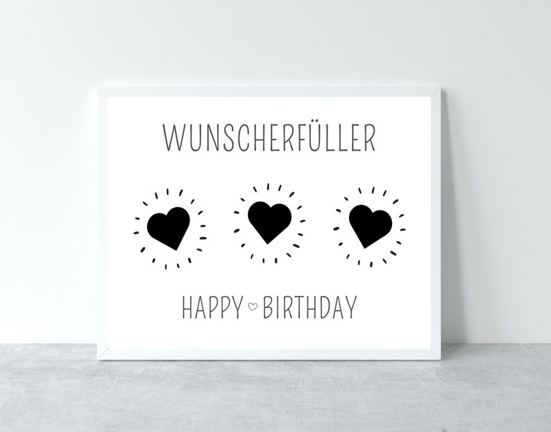 Puede incluir: Una tarjeta blanca con texto negro que dice "Wunschersch&uuml;ller" y "Feliz cumplea&ntilde;os". Hay tres corazones negros con contornos blancos en el centro de la tarjeta.
