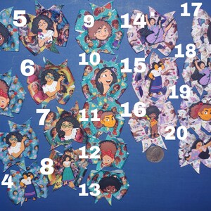 May include: A collection of twenty colorful hair bows, each featuring a different character from a popular animated movie. The bows are made of patterned ribbon and have character embellishments. The bows are arranged on a blue surface.