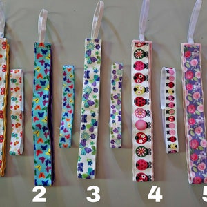 May include: Five different fabric headbands with various patterns, including butterflies, ladybugs and flowers. The headbands are numbered 1 through 5.