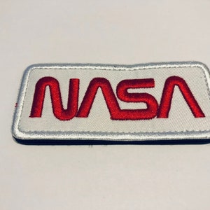 May include: A white embroidered patch with a red NASA logo.